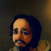 a man with a beard wearing headphones making a face