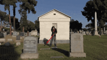 a man stands in a cemetery in front of a tombstone that says " gil "