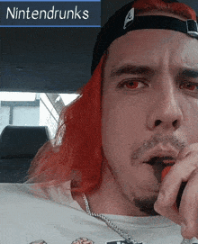 a man with red hair is wearing a hat that says nintendrunks on it