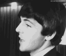a black and white photo of a man holding a microphone in his hand .