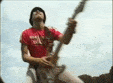 a man is playing a guitar in front of a blue sky .