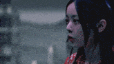 a close up of a woman 's face with a red shirt on