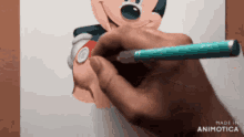 a person is drawing a picture of mickey mouse with a pencil