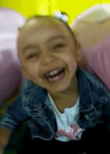 a little girl wearing a denim jacket and a shirt that says birthday
