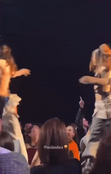 a woman with red hair is dancing on stage in front of a crowd