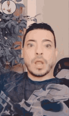 a man with a surprised look on his face has a picture of a doctor behind him