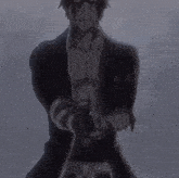 a man in a black suit is holding a gun in his hands .