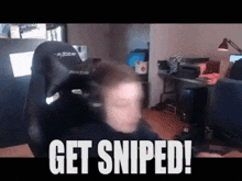 a man is sitting in a chair with the words get sniped on the bottom