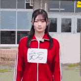 the girl is wearing a red jacket with a sign on her chest .