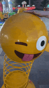 a person is touching a yellow smiley face on a spring