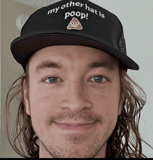 a man is wearing a hat that says my other hat is poop