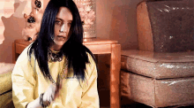 billie eilish is wearing a yellow sweatshirt with the word various on the front