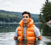 a man wearing an orange life vest is standing in the water