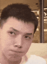 a young man is making a funny face and looking at the camera .