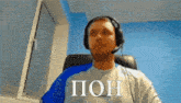 a man wearing headphones and a microphone says " poh "