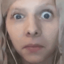 a close up of a woman making a funny face with her eyes wide open .