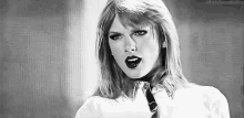 a black and white photo of taylor swift wearing a tie .