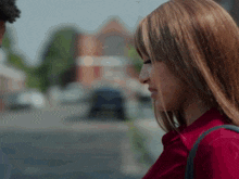 a woman in a red shirt is looking at another woman