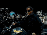 a man in a black jacket is riding a motorcycle on a yellow background