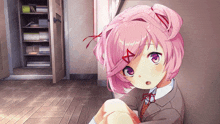 a girl with pink hair and purple eyes is sitting in a room