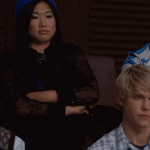 a woman wearing a blue hat sits next to a man with blonde hair