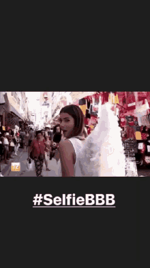 a girl with angel wings is taking a selfie