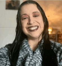 a woman wearing a sweater is smiling with her mouth open