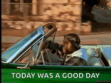 a man is driving a green car with the words today was a good day below him