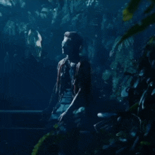 a person is standing in a dark forest with a blurred background