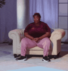 a woman is sitting in a chair wearing a maroon shirt that says ' ucsd ' on it