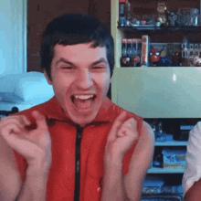 a man in a red shirt is making a funny face with his mouth open