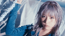a woman with purple hair wearing a blue denim jacket