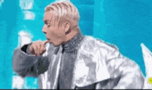 a man in a silver jacket is standing on a stage .