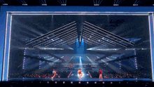a group of people are performing on a stage in front of a crowd of people