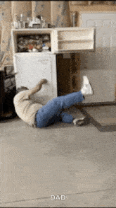 a man is laying on his back in front of a refrigerator with the word dad on the bottom right