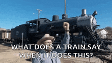 a man in a cowboy hat stands in front of a train with the words what does a train say