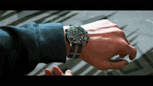 a man is wearing a watch that says ' rolex ' on the face