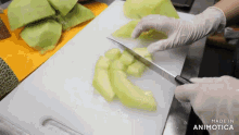 a person is cutting a melon on a cutting board
