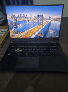 a laptop with a picture of a bridge on the screen shows the time as 16:29