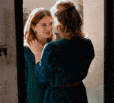 two women are looking at each other in a mirror