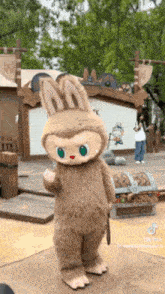 a mascot in a bunny costume is standing in front of a stage .