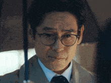 a man in a suit and tie holds an umbrella