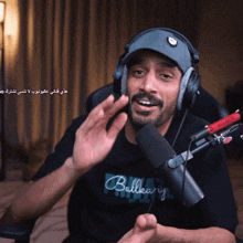 a man wearing headphones and a shirt that says bullkary talks into a microphone