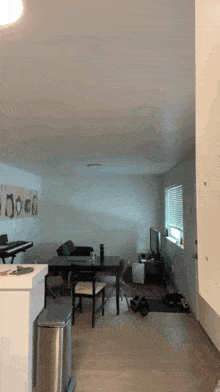 a dining room with a table and chairs and a trash can