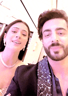 a man and a woman are posing for a selfie together