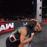 a woman in a wrestling ring with the word aw on the wall