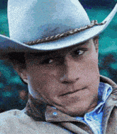 a close up of a man wearing a cowboy hat and jacket