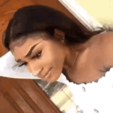 a woman is laying on a bed with her head on a pillow and smiling .