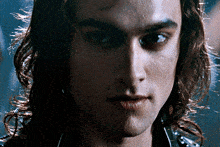 a close up of a man with long hair