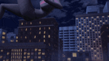a city at night with a tree in the foreground and a building in the background